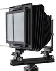Photo of ARCA-SWISS F-Metric 8x10 View Camera with quartering view, showing 8x10 Bail. Featuring telescopic optical bench, base tilt and ARCA-SWISS Micro-Orbix® tilt. From ARCA-SWISS USA. SKU: 013181-OC