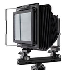 Photo of ARCA-SWISS F-Metric 8x10 View Camera with quartering view, showing 8x10 Bail. Featuring telescopic optical bench, base tilt and ARCA-SWISS Micro-Orbix® tilt. From ARCA-SWISS USA. SKU: 013181-OC